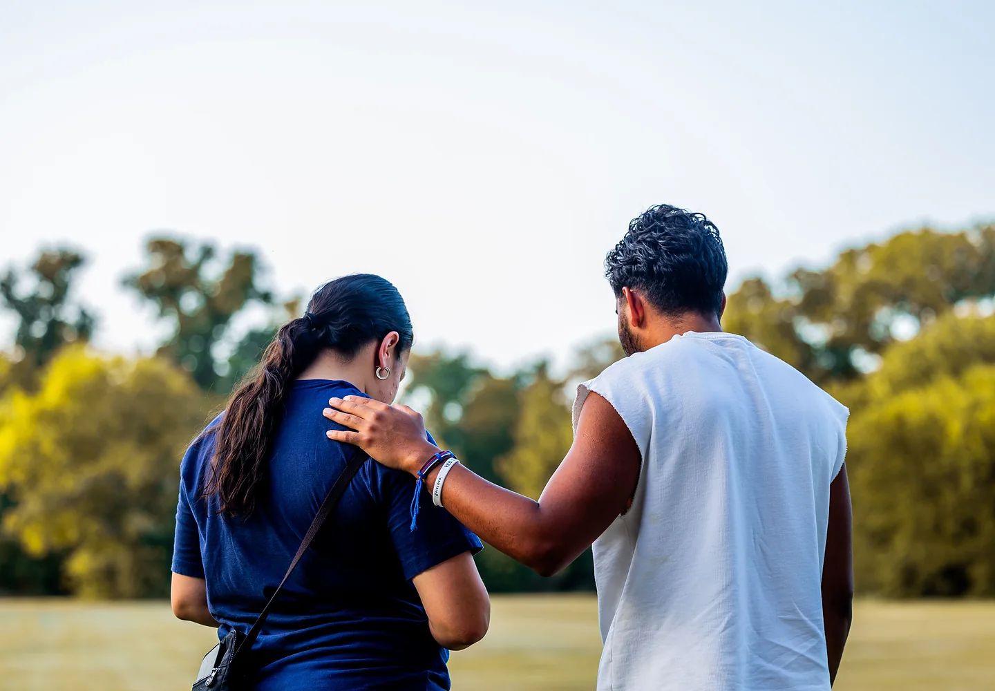 Two young people supporting one another outdoors