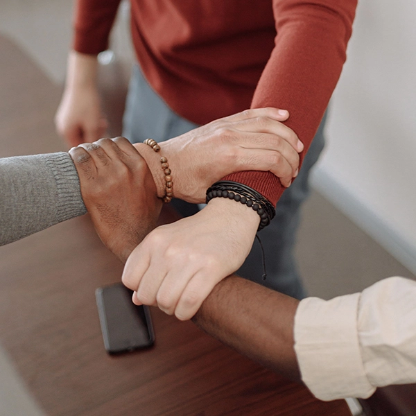 People placing their hands together in support