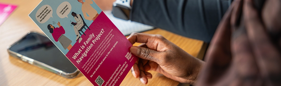 A person holding a Family Navigation Project brochure